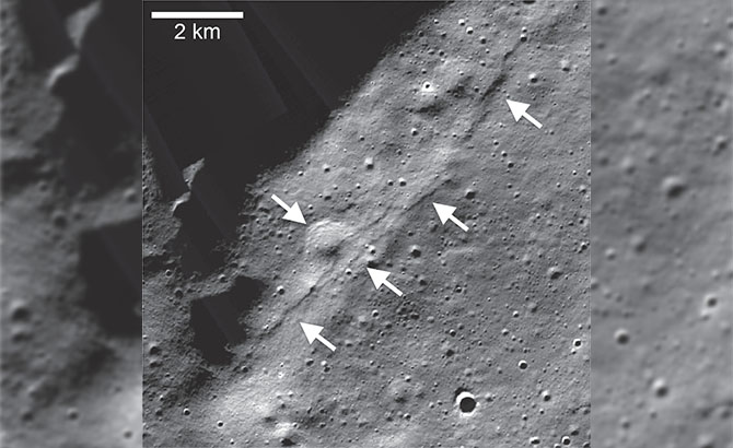 La flecha superior muestra un escarpe que atraviesa un cráter degradado de 1 km